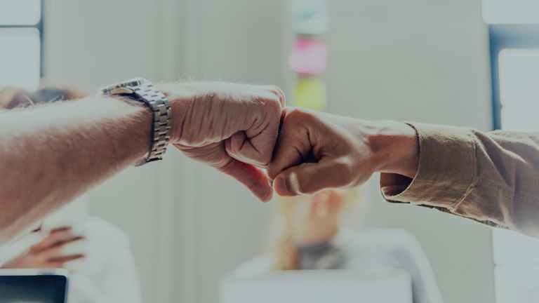 two person making fist contact